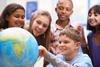 Kids gathered around a globe.