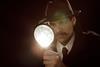 Photo of a detective or photo of a magnigying glass.