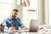 Photo of a business professional writing or typing on a computer.