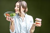 woman deciding between healthy and junk food