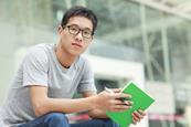 Asian young male wearing glasses and holding a book