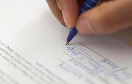 Photo of someone writing or signing a contract. Alternatively, just the photo of a contract.