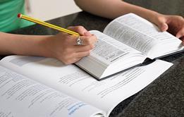 Photo of someone reading, ideally in a formal setting to suggest the idea of exam. If too complicated, then photo of a book or reading materials.