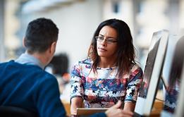 Photo of two people speaking in an exam context. If too complicatd, photo of speech bubbles to suggest the idea of speaking.