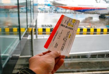 Hand holding plane ticket at airport.