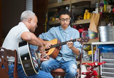 Grandfather and grandson playing guitar