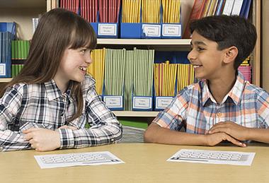 Photo of children speaking to each other or to their teacher.