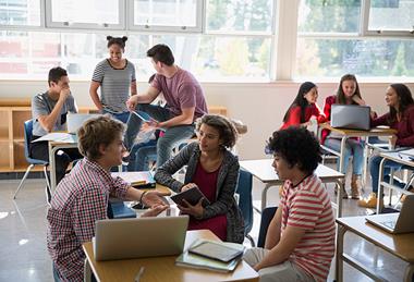 Photo of students speaking to each other.