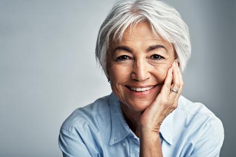 Elderly woman looking at camera, smiling