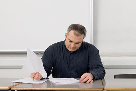 Photo of a teacher marking papers.