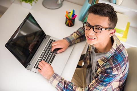 Photo of a student/s writing (can be in a notebook or on a laptop).