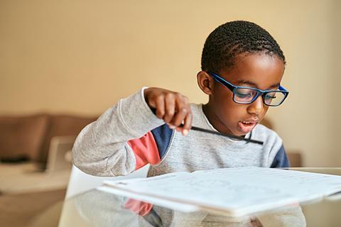 Photo of children drawing, writing or reading.