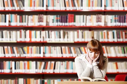 Photo of students reading in a classroom or in a library.