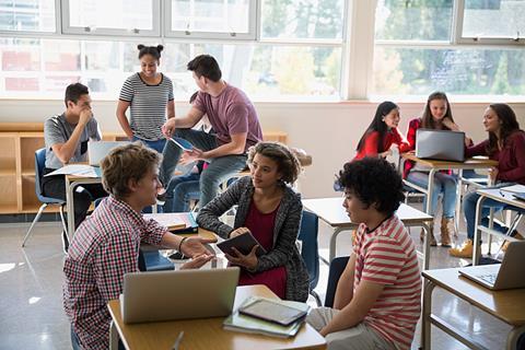 Photo of students speaking to each other.