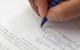 Photo of someone writing or signing a contract. Alternatively, just the photo of a contract.